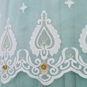 Dettaglio in tessuto a rete verde con ricamo floreale bianco e strass per copertura condizionatore