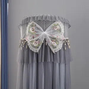 Grey cylindrical air conditioner dust cover detail, mesh lace with embroidered bow design.