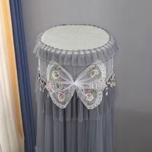 Grey upright cylindrical air conditioner dust cover with elegant lace bow and mesh design.