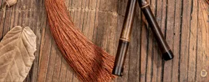 Detail shot of traditional Chinese bamboo fan handle and brown tassel, antique cultural craft.