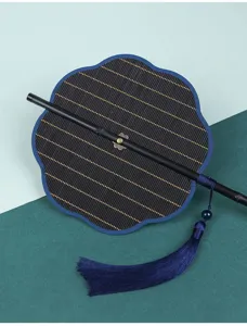 Gedetailleerde opname van traditionele zwart gestreepte opvouwbare bamboe waaier kwast