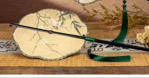 Détail d'éventail rond à long manche style chinois, broderie de prunier élégante et gland vert.