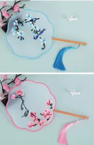 Detailed view of traditional Chinese embroidered round fans with wooden handles and colorful tassels.
