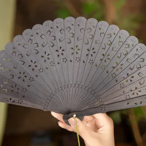 Handheld premium sandalwood folding fan with hollow carved floral pattern for traditional hanfu.