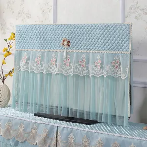 Vista dettagliata della copertura TV trapuntata blu con pizzo e decorazione floreale.