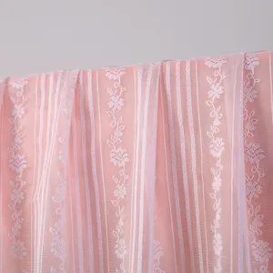 Primo piano dettaglio tessuto pizzo rosa con strisce verticali e ricamo floreale delicato