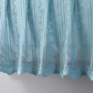 Primo piano dettagliato del tessuto in pizzo azzurro con righe verticali e bordo smerlato.