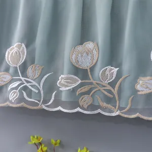 Close-up of light green sheer AC dust cover featuring delicate tulip embroidery and scalloped hem.