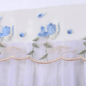 Detail van het blauwe bloemborduursel op de witte stof van de airco stofhoes.