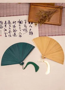 Vista detallada del abanico plegable de bambú de estilo chino con borla y hermosa caligrafía.