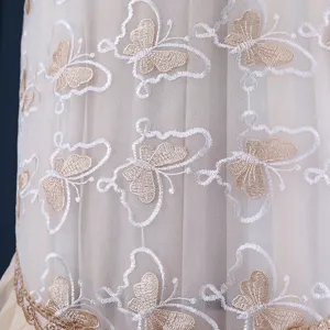 Primo piano di tessuto in rete di pizzo ricamato con farfalle squisite ed eleganti.