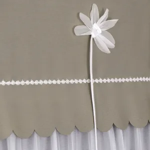 Detailaufnahme der Staubschutzhaube aus Stoff, mit weißer Spitzenborte und Textilblume verziert.