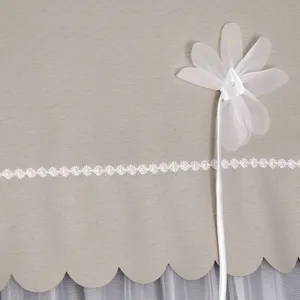 Nahaufnahme der beige Staubschutzhülle mit zarter weißer Spitzenborte und eleganter Chiffonblume.