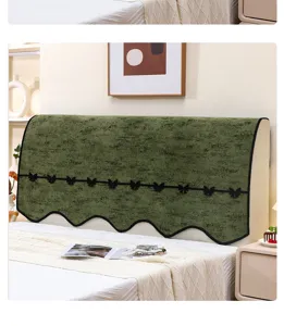 Detalle de funda para cabecera de cama de chenilla verde con banda y borde festoneado.