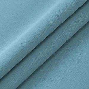 Detailansicht von einfarbigem hellblauem Stoff mit feiner Textur, weichem Material und Fall.