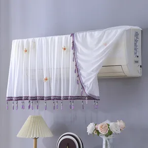 Vue détaillée d'une housse de climatiseur blanche avec franges violettes et fleurs.