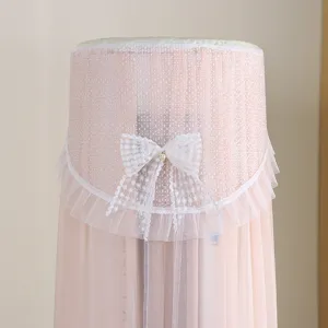 Copertura antipolvere rosa per climatizzatore a colonna con elegante fiocco in pizzo.