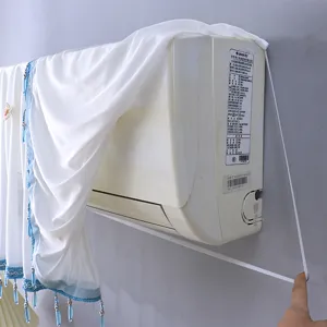 Détail de housse anti-poussière de climatiseur en dentelle blanche avec perles suspendues.