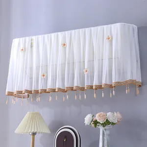 Housse de climatiseur en dentelle blanche avec appliques florales et franges de perles.