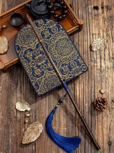 Detailansicht des traditionellen chinesischen Fächers, violetter Bambusgriff mit blauer Quaste.