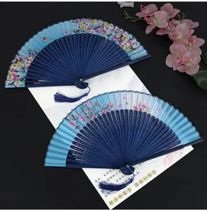 Chinese style folding hand fan with floral pattern and tassel for dance performance.