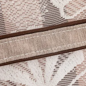 Detalle de tela de encaje para cubierta antipolvere con banda elástica marrón y costuras finas.