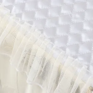 Detalle de funda para lavadora acolchada blanca, volante de encaje elegante, tela suave
