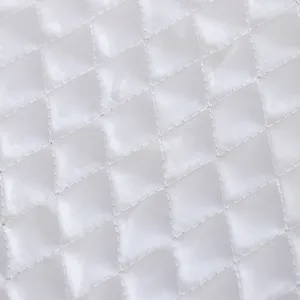 Detalle de tela acolchada blanca para funda de lavadora primer plano textura suave costuras