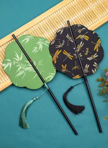 Exquisite traditional Chinese fan detail showing bamboo patterns with delicate tassels.