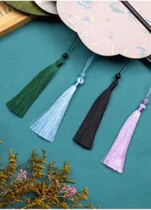Detail shot of traditional Chinese style embroidered round fan and elegant colorful tassels.