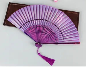 Close-up of traditional purple silk folding fan featuring delicate floral patterns and tassel.