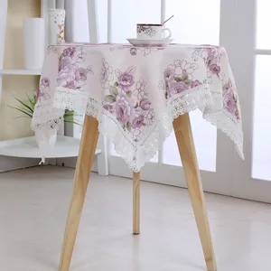 Detailed view of the elegant cotton linen tablecloth with purple floral print and white lace trim.