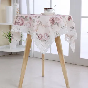 Detailed view of the vintage floral fabric tablecloth featuring delicate lace border trim.