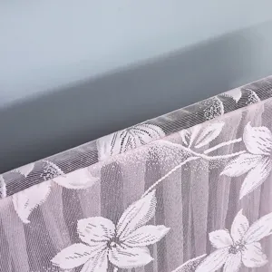 Close-up of pink floral lace TV dust cover showing detailed woven fabric texture and edge.