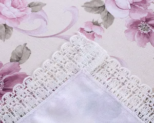 Close-up detail of vintage floral cotton linen tablecloth featuring elegant white lace trim.