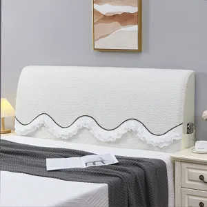 Detail view of white textured headboard cover with wavy ruffled edge and side pocket.