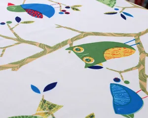 Cotton linen tablecloth fabric close-up detail with fresh bird and tree print, nice home decor.