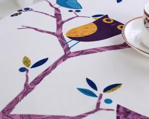 Cotton linen tablecloth close-up featuring charming owl and branch print, perfect for home decor.