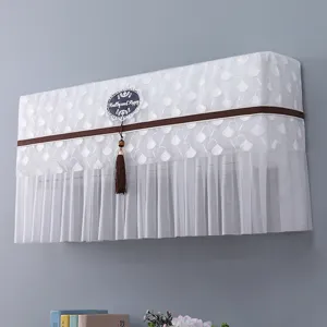 Copertura antipolvere per condizionatore in pizzo bianco con nappa e nastro marrone.