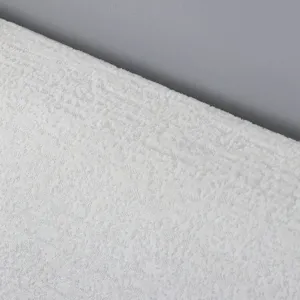 Close-up detail view of white textured fabric material for soft bed headboard cover.