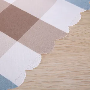 Detailed view of the plaid fabric dust cover featuring a stylish scalloped edge and soft texture.