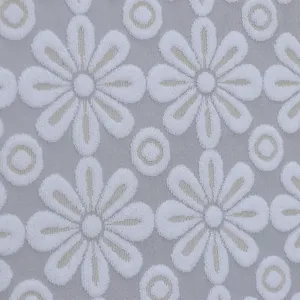 Close-up detail shot of white floral lace fabric, featuring delicate daisy embroidery texture.