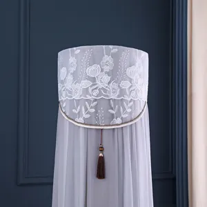 Elegante copricondizionatore verticale rotondo in pizzo grigio con ricamo floreale e nappa.