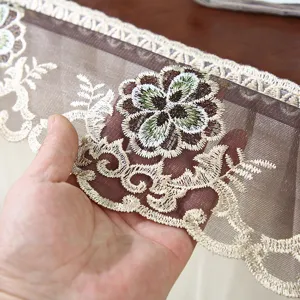 Primer plano detallado de mantel de encaje marrón con elegante bordado de flores.