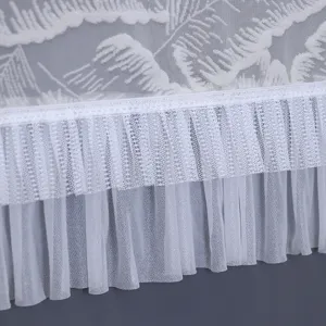 Close-up detail view of white lace dust cover showing delicate embroidery texture and ruffles.