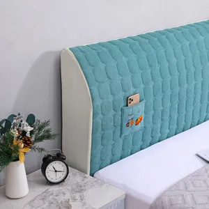 Detail view of quilted headboard cover with side storage pocket in teal fabric for bedroom.