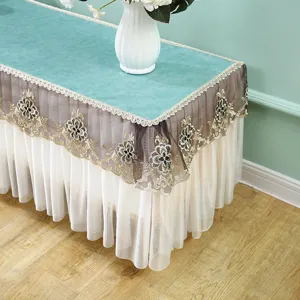 Camino de mesa rectangular verde funda antipolvo elegante con bordado y volantes blancos.