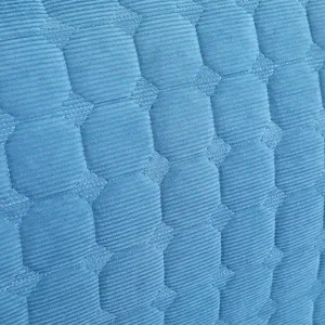 Close-up detail view of blue quilted headboard cover fabric with clear geometric pattern.