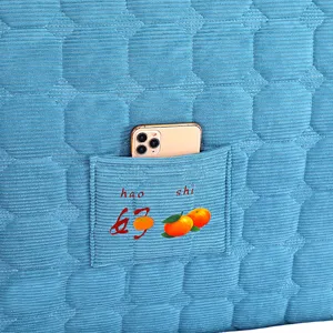 Detailed shot of quilted blue headboard slipcover with storage pocket for bedroom decor.