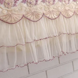 Detailed view of elegant beige lace air conditioner cover with purple floral embroidery.